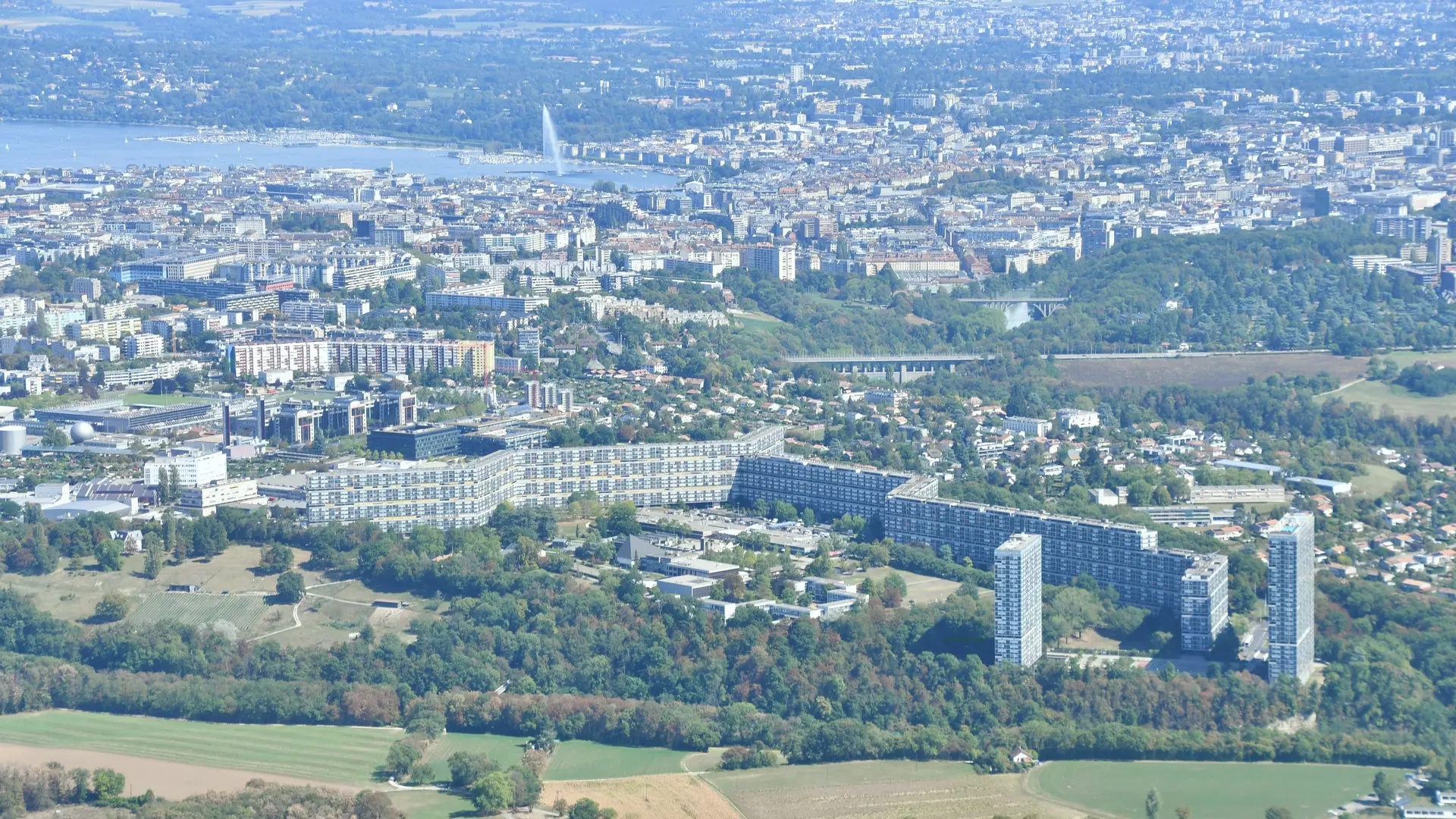 Vue aérienne du Lignon, Genève — la cité d’ancrage de Renovhome SA, avec la rade et le Jet d’eau au fond